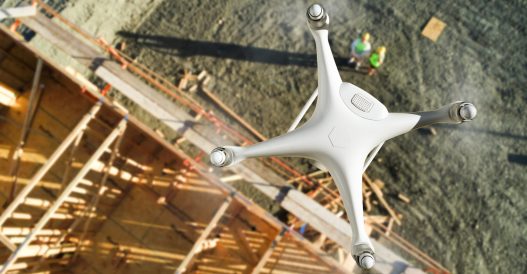 Unmanned Aircraft System (UAV) Quadcopter Drone In The Air Above Construction Site.